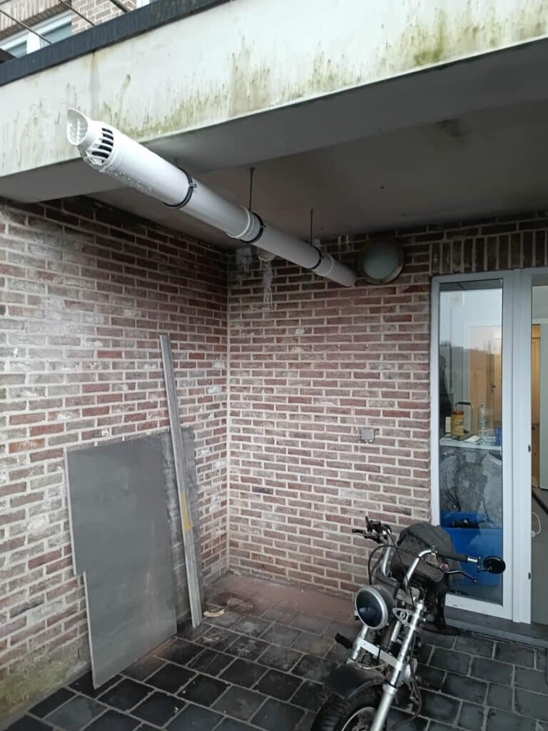 Nieuwe rookgasafvoer in wit kunststof langs de gevel na het plaatsen van een Vaillant condensatieketel