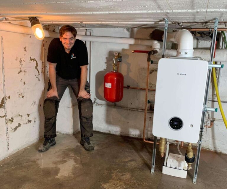 Technicus van HL Technieken bij een wandgemonteerde ketel tijdens een herstelling