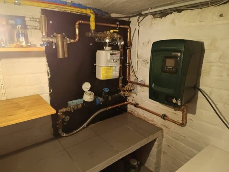 Drukverhogingspomp van DAB geplaatst naast de water- en gasmeter in een kelder in Mere