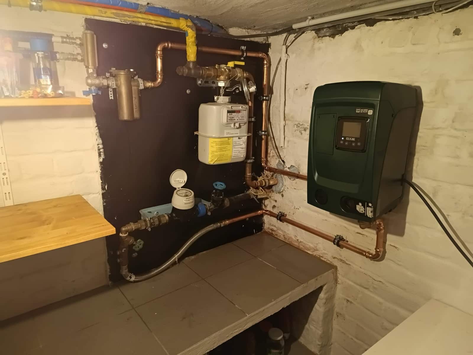 Drukverhogingspomp van DAB geplaatst naast de water- en gasmeter in een kelder in Mere